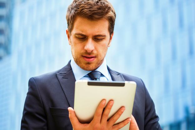 man checking his tablet | The Rules Of Email Etiquette