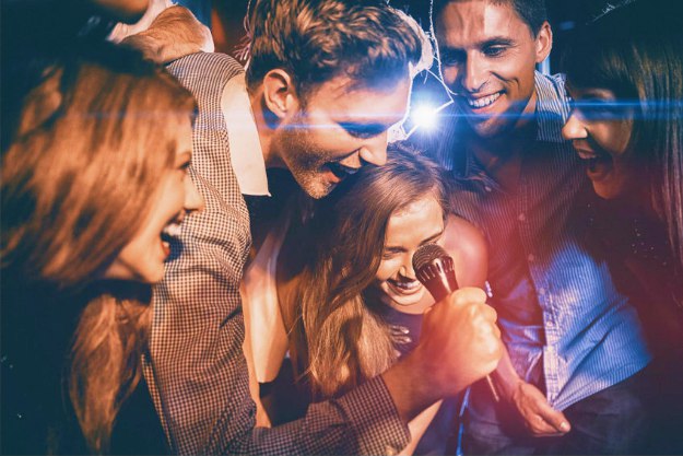 happy friends singing karaoke together nightclub | Team Building Activities That Will Boost Performance | team building activities for work