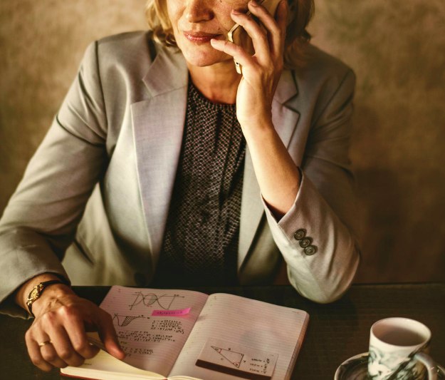woman holding smartphone while sitting on chair | Be More Assumptive In A Sales Call With These Tips | closing the deal