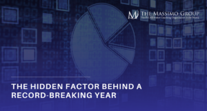 A promotional image with a dark blue and black textured background. Large, bold white and blue text reads, "The Hidden Factor Behind A Record-Breaking Year." A subtle "The Massimo Group" logo is visible in the top right corner.